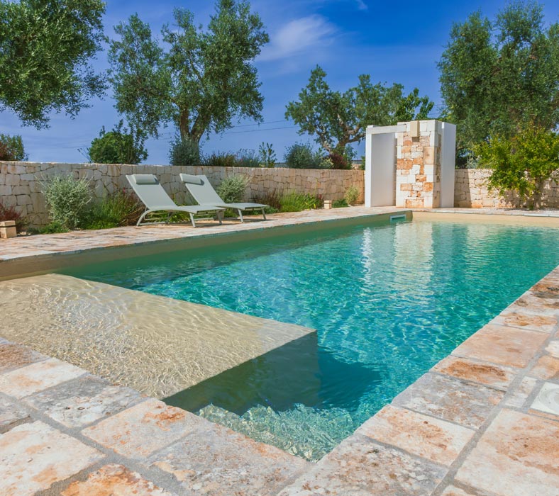 Piscina interrata rivestita in pietra naturale